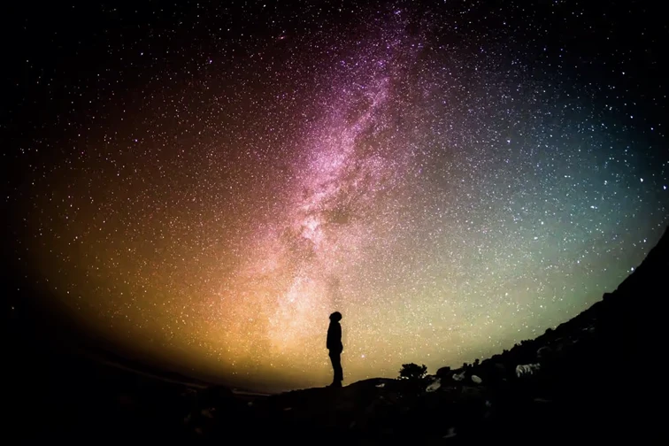 Silhouette of man looking up into the milky way